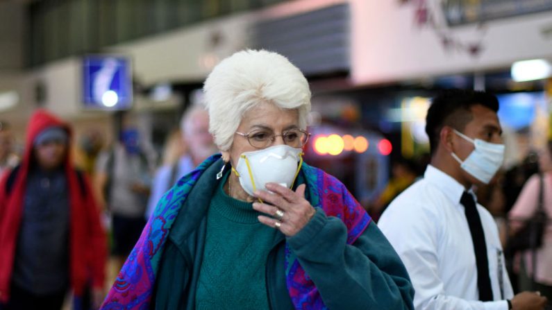 Una pasajera usa una máscara facial como precaución contra la propagación del nuevo coronavirus, en el Aeropuerto Internacional La Aurora de la Ciudad de Guatemala, Guatemala, el 12 de marzo de 2020. (JOHAN ORDONEZ/AFP vía Getty Images)