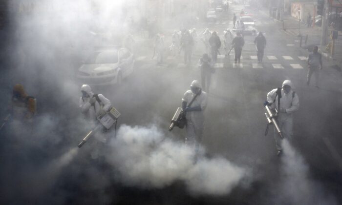 Bomberos iraníes desinfectan las calles de la capital, Teherán, en un intento de detener la salvaje propagación del coronavirus el 13 de marzo de 2020. (AFP vía Getty Images)