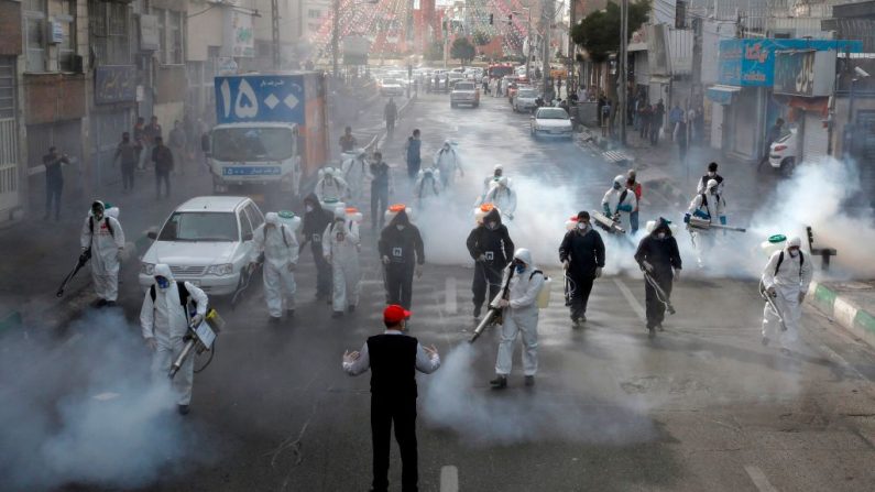 Bomberos iraníes desinfectan las calles de la capital, Teherán, en un intento de detener la propagación salvaje del coronavirus el 13 de marzo de 2020.  (AFP vía Getty Images)