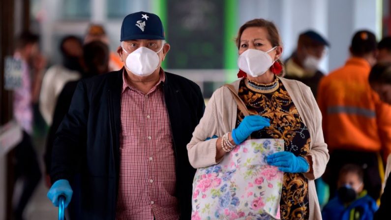 Los pasajeros de la terminal de autobuses de Bogotá utilizan mascarillas, como medida preventiva ante la pandemia mundial del COVID-19, en Bogotá el 13 de marzo de 2020. (RAUL ARBOLEDA/AFP vía Getty Images)