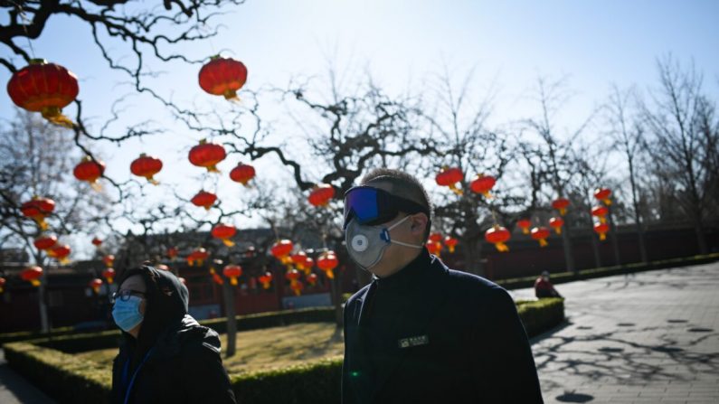 Un empleado del parque usando gafas y máscara en un parque en Beijing, China, el 14 de marzo de 2020. (Wang Zhao/AFP a través de Getty Images)
