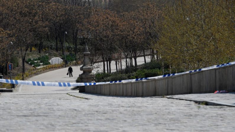 Hombre que pasea a su perro en el parque Rivera después de cruzar un cordón policial en Madrid el 15 de marzo de 2020. (OSCAR DEL POZO/AFP vía Getty Images)
