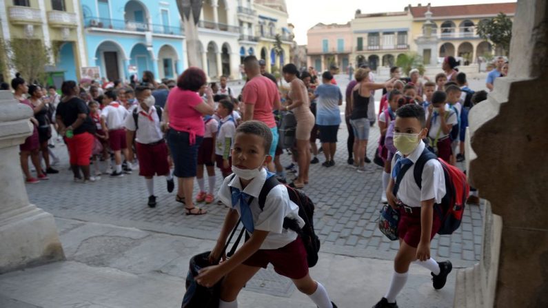 Alumnos con máscaras faciales como medida preventiva contra el nuevo coronavirus, COVID-19, llegan a la escuela en La Habana, el 16 de marzo de 2020. (YAMIL LAGE/AFP vía Getty Images)