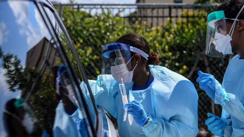 Personal médico toma muestras médicas de los pacientes en un laboratorio de pruebas de coronavirus "drive-thru" establecido por un centro comunitario local en West Palm Beach a 75 millas al norte de Miami, el 16 de marzo de 2020. (Foto de CHANDAN KHANNA/AFP vía Getty Images)
