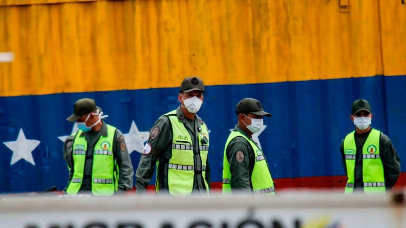 Los guardias nacionales venezolanos utilizan máscaras faciales, como medida preventiva contra la propagación del nuevo coronavirus, COVID-19, en la brigada internacional Simón Bolívar vista desde Cúcuta, Colombia, el 16 de marzo de 2020. (Foto de SCHNEYDER MENDOZA/AFP vía Getty Images)
