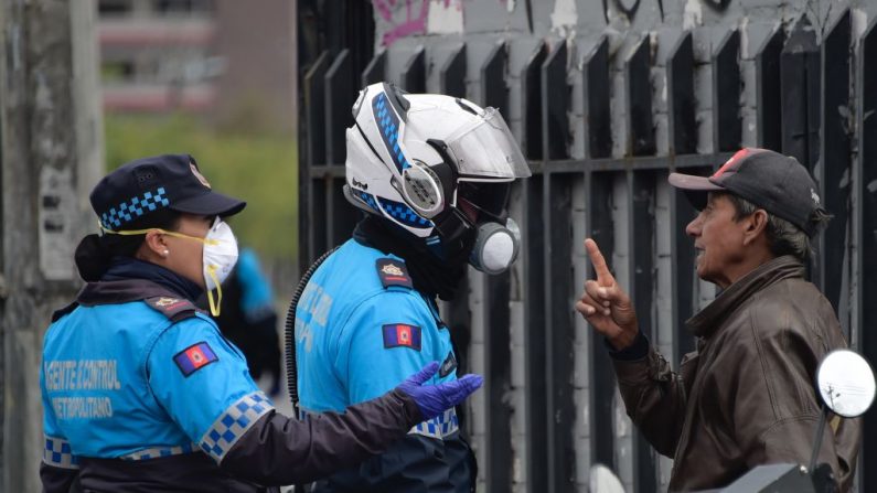 Un hombre discute con los oficiales de la policía metropolitana que patrullan las calles de Quito, Ecuador, el 17 de marzo de 2020 después de que el gobierno ecuatoriano declarara el estado de emergencia y ordenara un toque de queda como un esfuerzo para detener la propagación del rápido brote del virus del PCCh. (RODRIGO BUENDIA/AFP vía Getty Images)