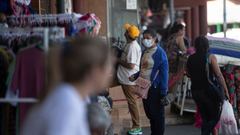 Una mujer usa una máscara facial como medida de precaución contra la propagación del virus del PCCh, en un mercado de Managua, Nicaragua, el 17 de marzo de 2020. (INTI OCON/AFP vía Getty Images)