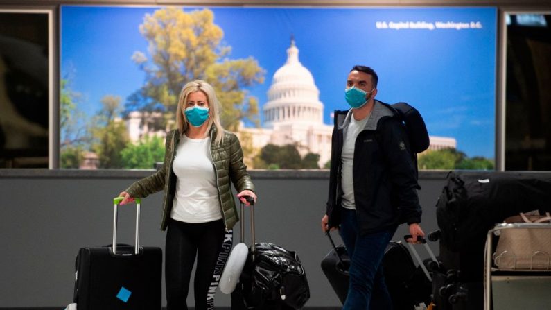 Pasajeros usan máscaras cuando llegan al aeropuerto internacional de Dulles en Dulles, Virginia, el 17 de marzo de 2020. (Andrew Caballero-Reynolds / AFP a través de Getty Images)