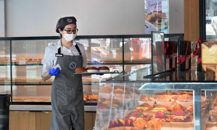 Una empleada de un cafetería y panadería usa una mascarilla en Los Ángeles, California, el 17 de marzo de 2020. (Frederic J. BROWN/AFP vía Getty Images)