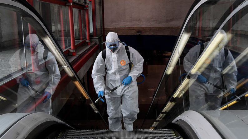 Un miembro de la Unidad Militar de Emergencias (UME) realiza una desinfección general en la estación de metro de Nuevos Ministerios en Madrid, España, el 18 de marzo de 2020. (OSCAR DEL POZO/AFP vía Getty Images)