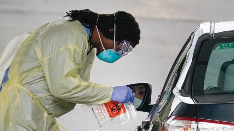Una trabajadora de la salud examina a un paciente de COVID-19 en un sitio de pruebas de virus del PCCh a pie de carretera el 18 de marzo de 2020 en Arlington, Virginia. (Foto de Drew Angerer/Getty Images) 