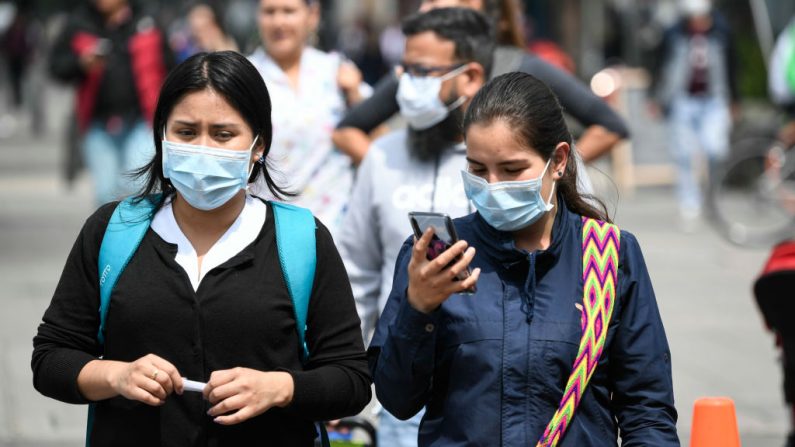 Mujeres usan máscaras faciales como medida de precaución contra la propagación del virus del PCCh, en Bogotá, Colombia, el 18 de marzo de 2020. (JUAN BARRETO/AFP vía Getty Images)