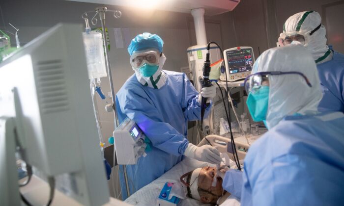 Personal médico trata a pacientes con el virus del PCCh en un hospital de Wuhan, China, el 19 de marzo de 2020. (STR/AFP a través de Getty Images)