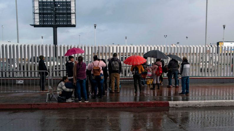 Solicitantes de asilo esperan noticias fuera del puerto de entrada de El Chaparral en la frontera entre EE. UU. y México en Tijuana, estado de Baja California, México, el 19 de marzo de 2020. (GUILLERMO ARIAS/AFP vía Getty Images)