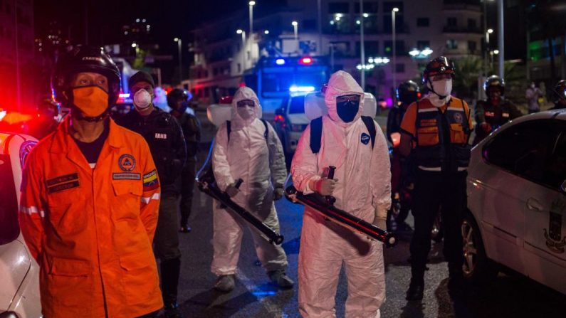 Trabajadores municipales con equipo de protección participan en una campaña de limpieza como medida preventiva contra la propagación del virus del PCCh, en Caracas, Venezuela, el 21 de marzo de 2020. (CRISTIAN HERNANDEZ/AFP vía Getty Images)