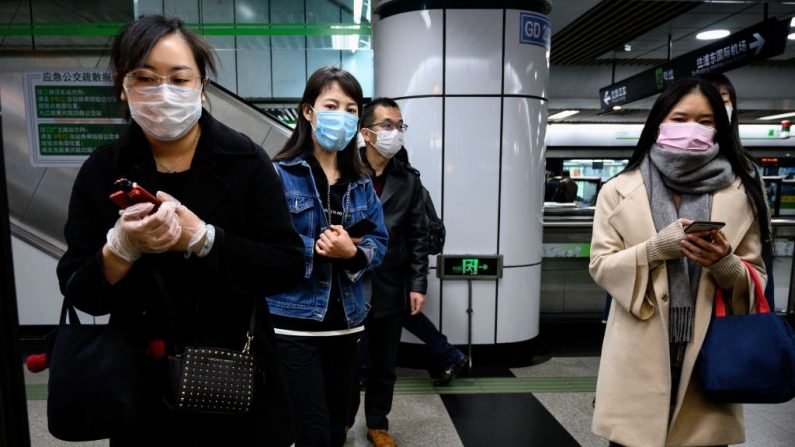 Las personas que usan máscaras faciales esperan un tren en una estación de metro en Shanghai el 23 de marzo de 2020. (Noel Celis/AFP a través de Getty Images)
