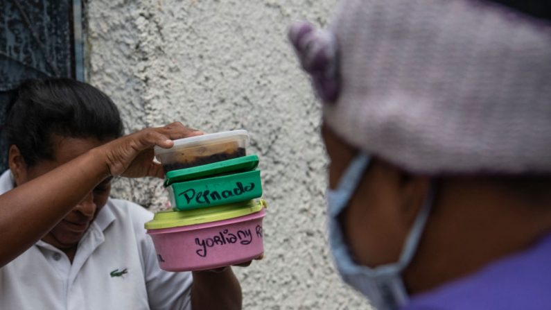 Una mujer de la comunidad local recibe comida gratis como parte de la iniciativa del gobierno en Petare el 23 de marzo de 2020 en Caracas, Venezuela. (Carlos Becerra/Getty Images)