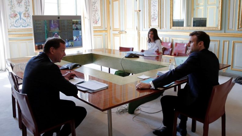 El presidente francés Emmanuel Macron (d) asiste a una videoconferencia con los líderes del G20 para discutir el virus del PCCh, brote en el Palacio del Elíseo en París, Francia, el 26 de marzo de 2020. (BENOIT TESSIER/POOL/AFP vía Getty Images)