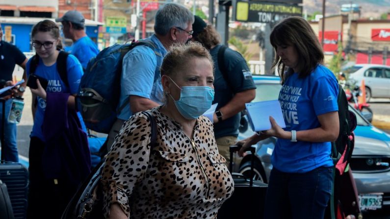 Ciudadanos estadounidenses se preparan para abordar un vuelo comercial para regresar a su país durante el brote del virus del PCCh, en el aeropuerto internacional de Toncontin en Tegucigalpa, Honduras, el 26 de marzo de 2020. (ORLANDO SIERRA/AFP vía Getty Images)