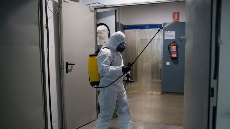 Un miembro de la Unidad de Emergencias Militares (UME) ayuda en la desinfección general del centro de atención extendida de Sant Antoni, en Barcelona, el 27 de marzo de 2020. (JOSEP LAGO/AFP a través de Getty Images)