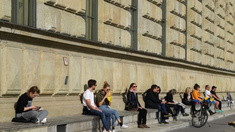 La gente disfruta del clima cálido y soleado frente a la residencia en el lugar de Max-Joseph en la ciudad de Munich, al sur de Alemania, el 27 de marzo de 2020, ya que la vida pública en Baviera ha sido limitada debido al coronavirus COVID-19. (CHRISTOF STACHE/AFP vía Getty Images)
