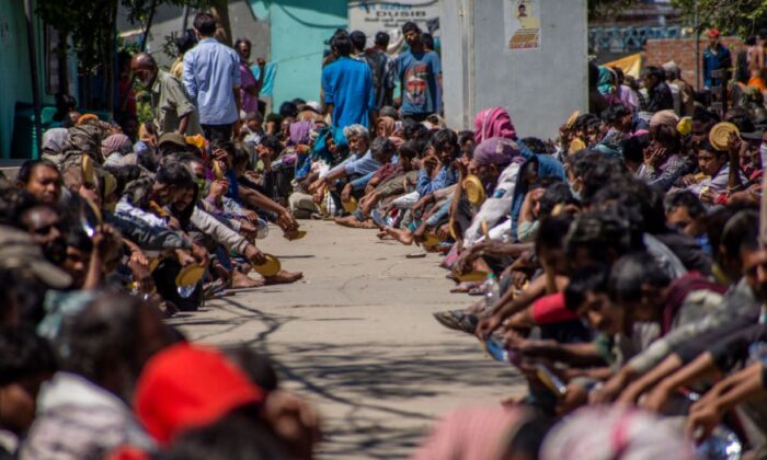 Trabajadores y personas sin hogar esperan comida fuera de un refugio administrado por el gobierno, mientras continúa un bloqueo nacional en un intento por detener la propagación del coronavirus (COVID-19), el 28 de marzo de 2020, en Nueva Delhi, India . (Yawar Nazir/Getty Images)