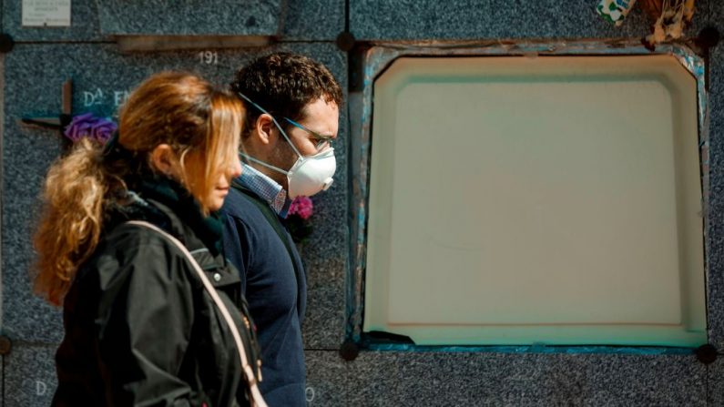 Un hombre con una máscara facial llega para el entierro de una víctima del virus del PCCh al cementerio de Fuencarral en Madrid, España, el 29 de marzo de 2020. (BALDESCA SAMPER/AFP vía Getty Images)