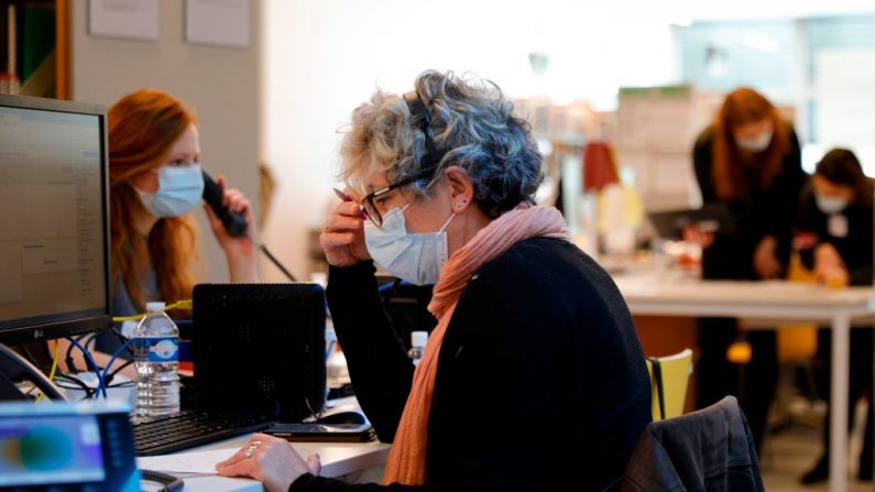 Personas trabajan en un centro de llamadas de Covidom, una nueva aplicación de monitoreo médico a distancia, dentro del Campus Picpus de los hospitales públicos de París (AP-HP) el 30 de marzo de 2020, en París, durante un estricto bloqueo en Francia destinado a frenar la propagación del virus del PCCh. (GEOFFROY VAN DER HASSELT/AFP vía Getty Images)