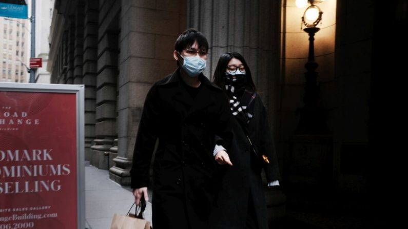 Una pareja con máscaras médicas camina por el distrito financiero de Manhattan, en la ciudad de Nueva York, el 3 de marzo de 2020. (Spencer Platt/Getty Images)