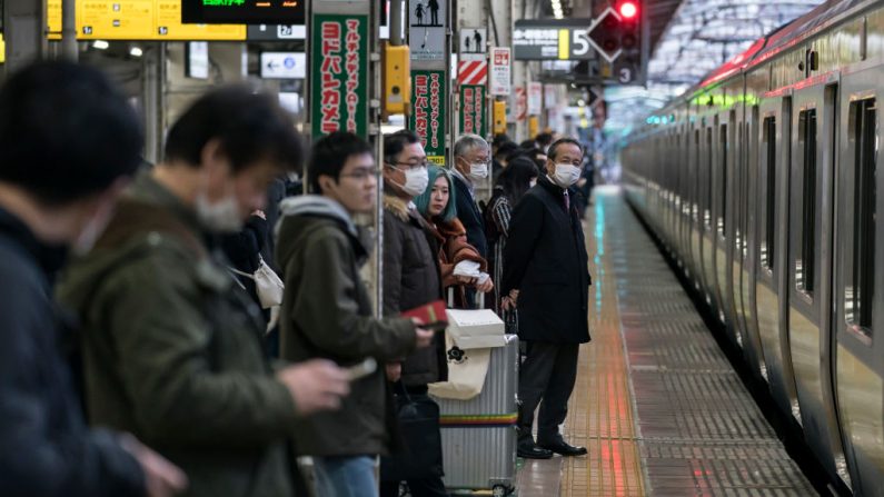Pasajeros con máscaras faciales esperan para abordar un tren en una estación de tren el 5 de marzo de 2020 en Tokio, Japón. (Tomohiro Ohsumi/Getty Images)