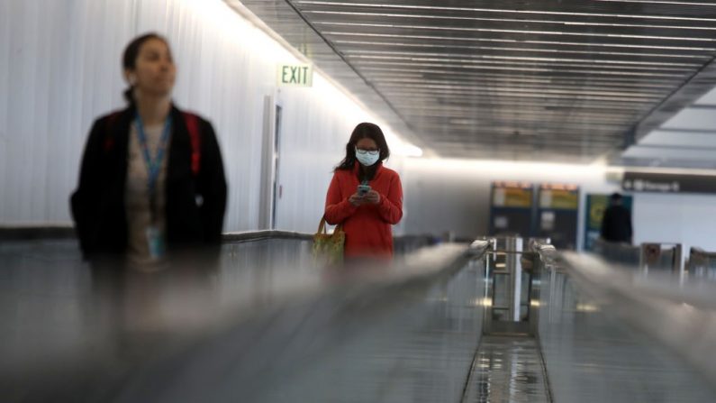 Una pasajera lleva una máscara protectora al entrar en la terminal internacional del aeropuerto internacional de San Francisco el 6 de marzo de 2020 en San Francisco, California. Tras el brote de COVID-19, las aerolíneas se enfrentan a importantes pérdidas. (Foto de Justin Sullivan/Getty Images)