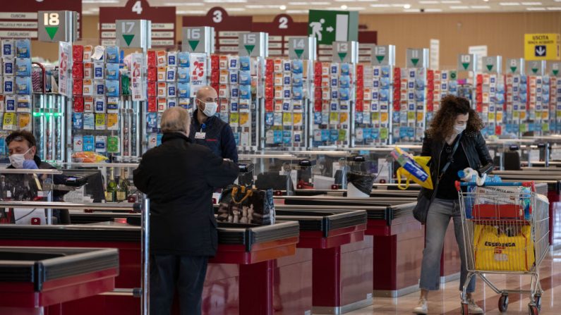 Clientes y cajeros, con máscaras faciales, son fotografiados en un supermercado el 11 de marzo de 2020 en Milán, Italia. (Emanuele Cremaschi/Getty Images)