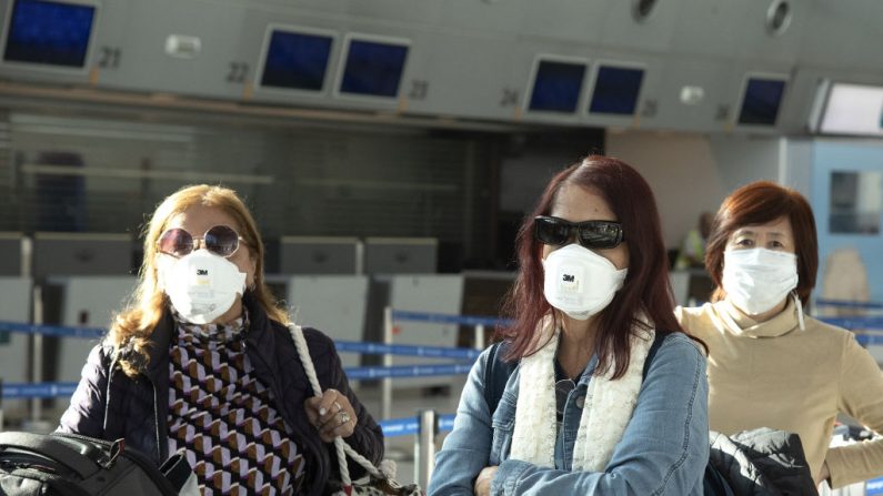 Los viajeros llevan máscaras protectoras en el Aeropuerto Internacional Ministro Pistarini el 13 de marzo de 2020 en Ezeiza, Argentina. (Lalo Yasky/Getty Images)