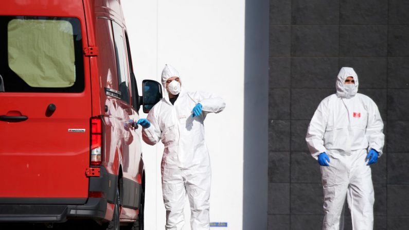 Los miembros de la Unidad Militar de Emergencia (UME) llevan las camionetas de los fallecidos para su almacenamiento en frío en la pista de hielo del Palacio de Hielo el 25 de marzo de 2020 en Madrid, España. (Carlos Alvarez/Getty Images)
