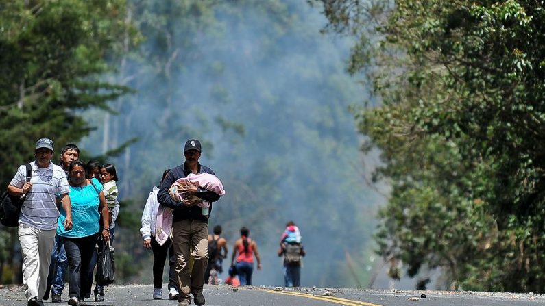 La gente camina a lo largo de la carretera Panamericana, bloqueada por un grupo de manifestantes en el pueblo de El Cairo, zona rural de Piendamo, departamento del Cauca, Colombia, el 21 de agosto de 2013. (Foto de archivo de LUIS ROBAYO/AFP vía Getty Images)