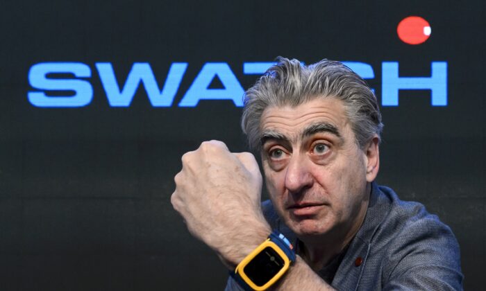 El director general del grupo de relojes suizos Swatch Group, Nick Hayek, muestra el reloj de pulsera Swatch Touch Zero One durante una conferencia de prensa en Corgemont, Suiza, el 12 de marzo de 2014. (Fabrice Coffrini/AFP vía Getty Images)