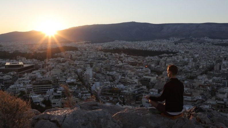 Esta fotografía tomada a principios de septiembre 7 de 2017, muestra al hombre practicando la meditación en la colina de La Pnyx en Atenas. (LUDOVIC MARIN/AFP vía Getty Images)