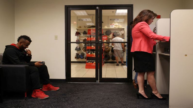 Dos personas esperan para ser entrevistadas para un trabajo marítimo durante una feria de trabajo en los grandes almacenes J.C. Penny en el Dadeland Mall el 17 de octubre de 2017 en Miami, Florida. (Foto de Joe Raedle/Getty Images)