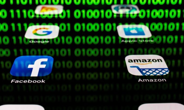 Las aplicaciones para Google, Amazon, Facebook, Apple, junto a la imagen de un código binario, se muestran en una pantalla de tableta en París, el 20 de abril de 2018. (Lionel Bonaventure/AFP a través de Getty Images)