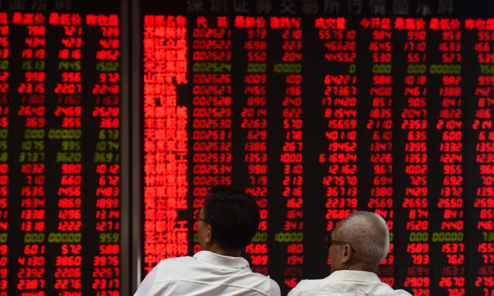 Inversionistas monitorean los movimientos del precio de las acciones en una compañía de valores en Beijing el 15 de junio de 2016. (Greg Baker/AFP/Getty Images)