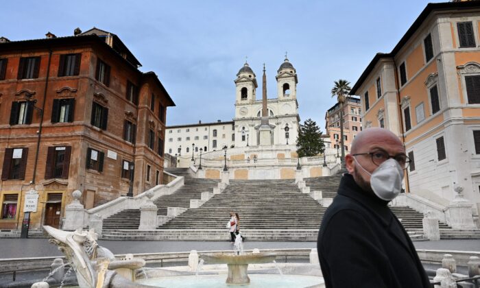 Un hombre con una máscara protectora camina por una desierta Piazza di Spagna en el centro de Roma, Italia, el 12 de marzo de 2020. (Alberto Pizzoli/AFP vía Getty Images)