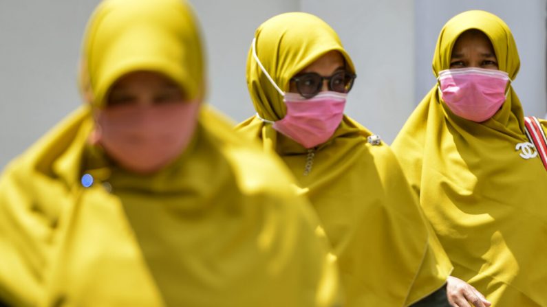 Mujeres con máscaras faciales caminan en un área pública en Banda Aceh, Indonesia, el 2 de marzo de 2020. (Chaideer Mahyuddin/AFP/Getty Images)