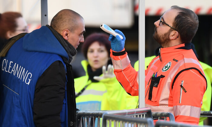 Un personal sanitario comprueba la temperatura corporal de un personal de limpieza que llega al estadio de la Juventus antes de un partido de fútbol en Turín, Italia, el 8 de marzo de 2020. (VINCENZO PINTO/AFP vía Getty Images)