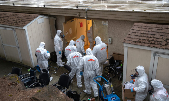 Un equipo con ropa protectora ingresa a un centro de atención médica a largo plazo donde ocurrió un brote de COVID-19 en Kirkland, Washington, el 12 de marzo de 2020. (John Moore / Getty Images)