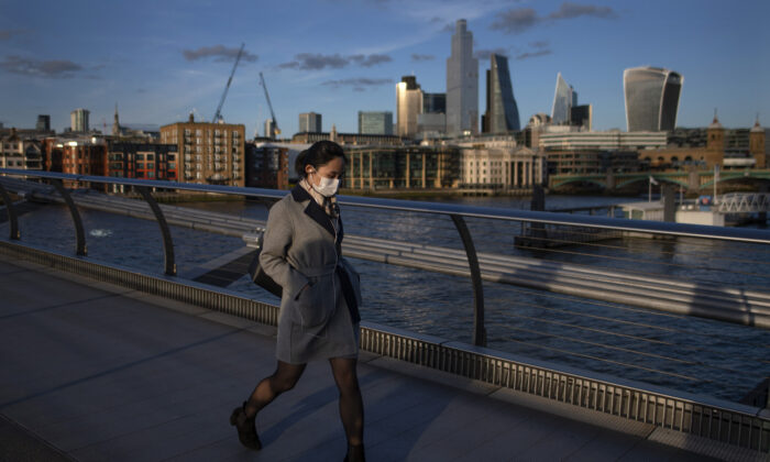 Una mujer cruza el puente del milenio con una máscara facial para protegerse del coronavirus en Londres, Inglaterra, el 16 de marzo de 2020. (Justin Setterfield/Getty Images)