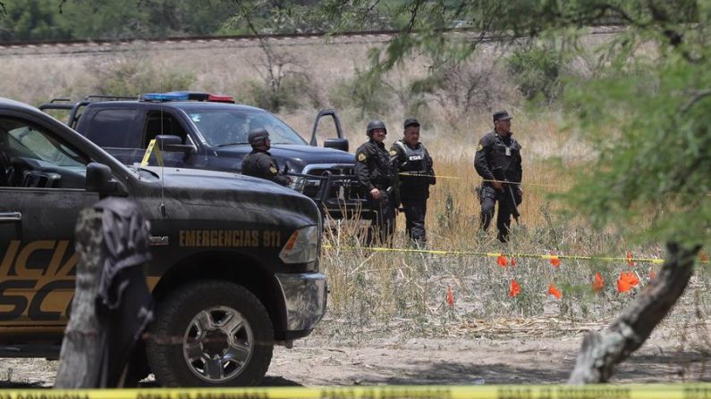Peritos de los servicios médicos forenses levantan los cuerpos de personas que murieron el 5 de junio de 2018, durante un enfrentamiento con las fuerzas federales en la localidad de Encarnación de Diaz, en el estado de Jalisco (México). EFE/Carlos Zepeda/Archivo
