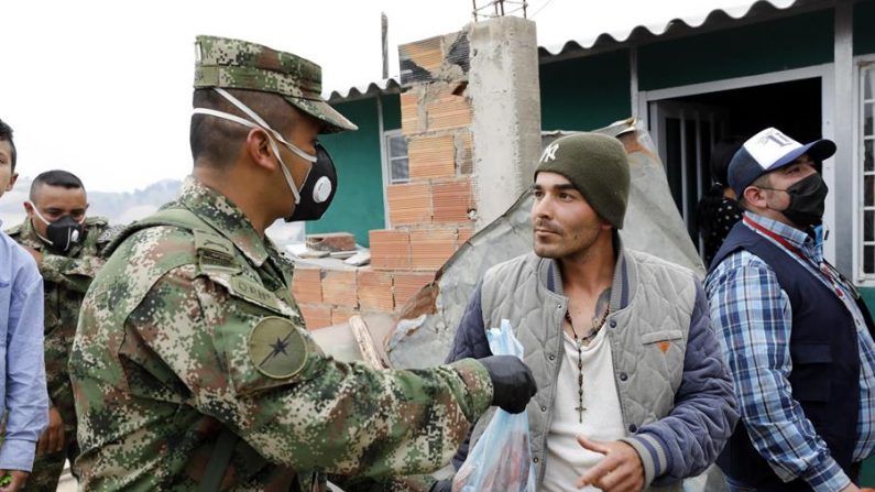 Soldados de la Brigada 13 del Ejército de Colombia distribuyen ayudas el 30 de marzo de 2020 a personas de bajos ingresos económicos, en el municipio de Soacha (Colombia). EFE/Mauricio Dueñas Castañeda
