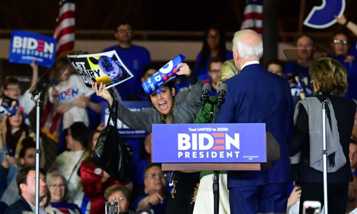 El aspirante a la candidatura demócrata, el ex vicepresidente Joe Biden y su esposa Jill observan mientras una manifestante del sector lácteo es detenida. (FREDERIC J. BROWN/AFP vía Getty Images)