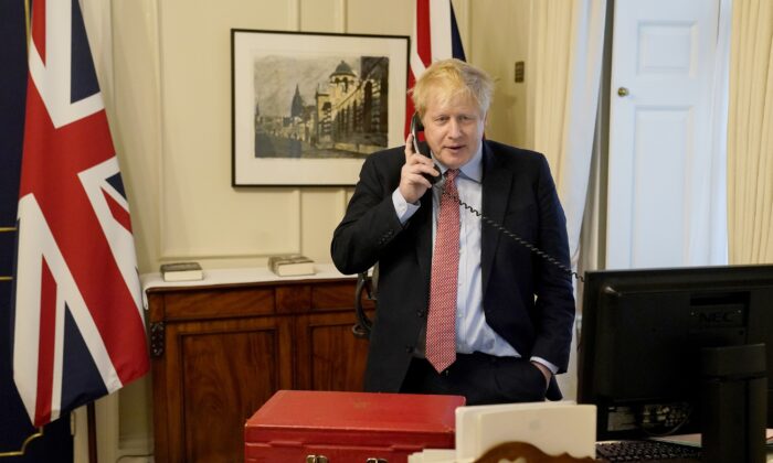 Primer ministro del Reino Unido hablando por teléfono el 25 de marzo de 2020 en el 10 de la calle Downing. (Andrew Parsons-WPA Pool/Getty Images)