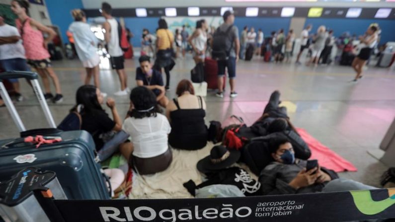 RIO DE JANEIRO (BRASIL), 20/03/2020.- Decenas de pasajeros esperan conseguir vuelos este viernes, en el aeropuerto internacional de Río de Janeiro (Brasil). EFE/ Antonio Lacerda
